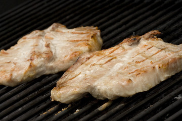 Pork chops on the grill.  Grill marks and close up detail