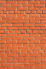 Simple brick wall laid with a red brick.