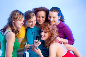 fünf wunderschöne Mädchen lesen eine SMS am Handy