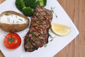 Grilled steak dinner with potato, and vegetables