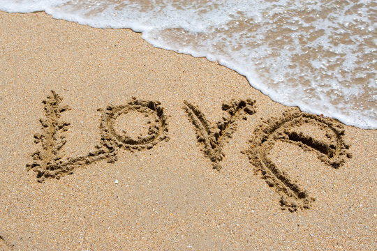 I love you written in the sandy beach.