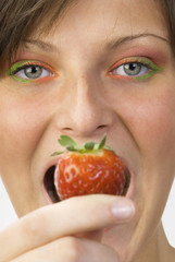 portrait of a young and cute brunette with big strawberry