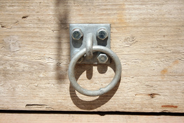 A metal ring attached to a wall of wood