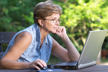 Mid adult woman working outdoors on the laptop