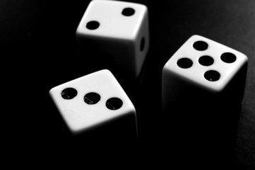 Three dice closeup in dramatic black and white light