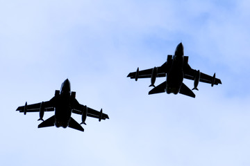 A silhouette of two Royal Air force RAF Panavia Tornado jet fighters against a blue sky.