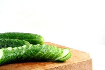 cucumbers on a wooden plate isolated on white