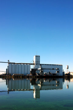 Waterfront Grain Silo Reflected near Seaport Loading Docks