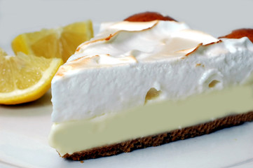 Lemon meringue pie with lemons in background.