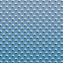 a very large sheet of light blue steel studded metal plate