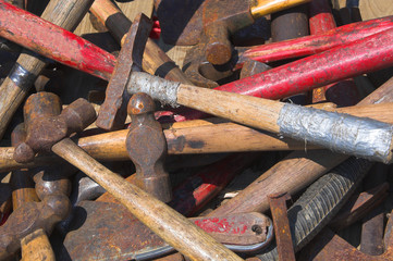 A large pile of assorted old hammers.