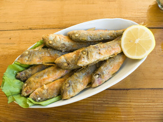 Appetizing snack a fried fish with a lemon
