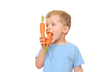 three years old boy eating fresh carrot isolated on white
