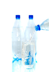 Bottles of mineral water with a glass. Isolated