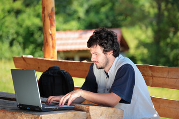 College student working on a laptop in the park