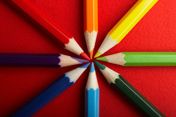 Fototapeta premium A Circle of Colored Pencils on Red Background 