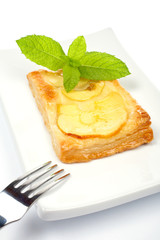 Apple tart with leaves of mint. Soft shadow, on white background