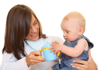 Obraz na płótnie Canvas mother and 8 months baby girl with baby cup isolated 