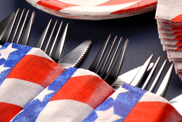 Several knives and forks in a 4th of July table setting
