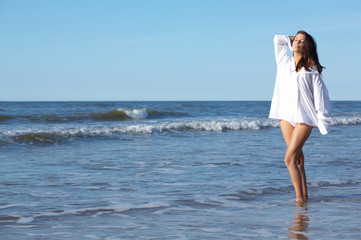 Fototapeta na wymiar 20-25 years old Beautiful Woman on the beach, wearing shirt