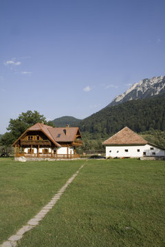Wooden mountain house in summer time with big garden