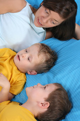 Fototapeta na wymiar mother and two sons in bed - little chat