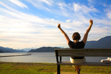 woman with her arms up over blue sky
