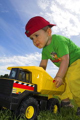 child playing with truck outside over deep blue sky