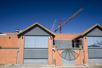 Construction canes behind urban clay building