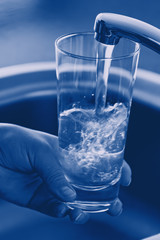 Pouring Fresh Tap Water Into a Glass. Shallow DOF. Focus on Tap.