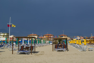 Umbellas and seats in a private beach of tuscany