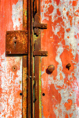 Old, rusty, abandoned metallic portal with locks and handle.