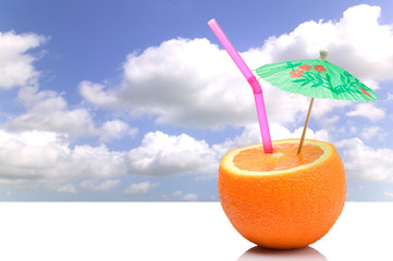 Concept image of a Summer orange cocktail against blue sky.