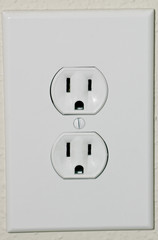 A close up shot of a gleaming white electrical power outlet.