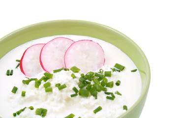 bowl of cottage cheese with chive and radish isolated on white