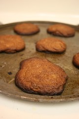 Close up view of a sheet of burnt cookies on a stove top