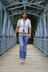 Young woman walking on a old bridge.