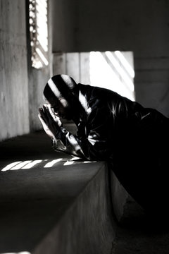 A Young Black Man Is On His Knees Praying