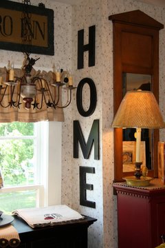 home letter sign displayed on flowered wallpaper