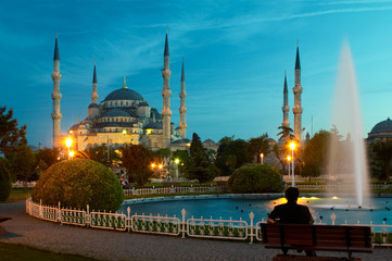 man sitting opposite blue mosque in istanbul in the evening