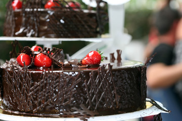 Dark chocolate mousse cake with cream and a strawberry