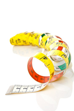 Curled measuring tape reflected on white background