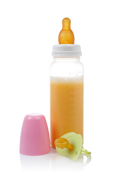 Baby bottle and pacifier reflected on white background