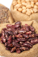 Burlap sack with red beans over a white background. Shallow DOF