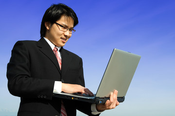 A businessman working on his laptop outdoor
