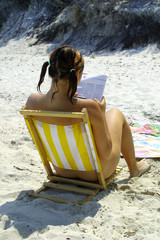 Nude girl reading on beach