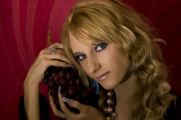 Fototapeta premium young beautiful blond girl with grapes