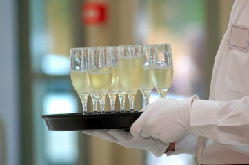 waiter with dish of vine glasses