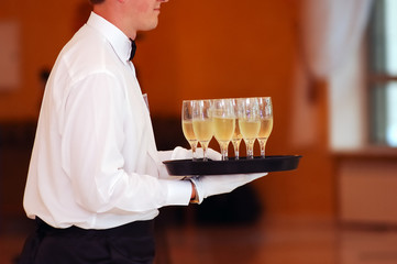 waiter with dish of vine glasses