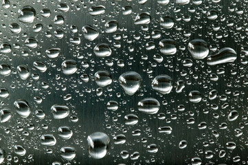 Water droplets on a brushed steel surface.